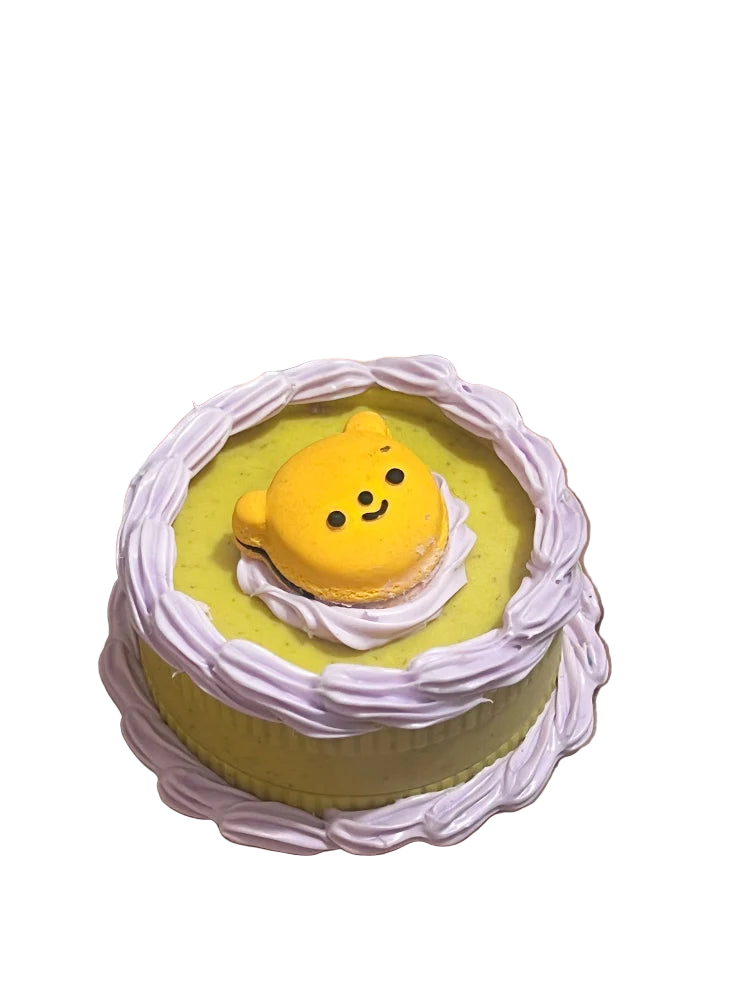 A yellow, pastry-inspired spice grinder with a decorative teddy bear design on top.