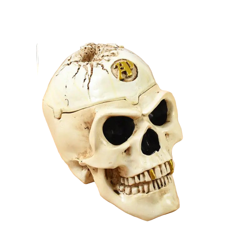 A decorative skull-shaped ashtray with a round form and Southeast Asian style, featuring gold accents on the eyes and mouth.